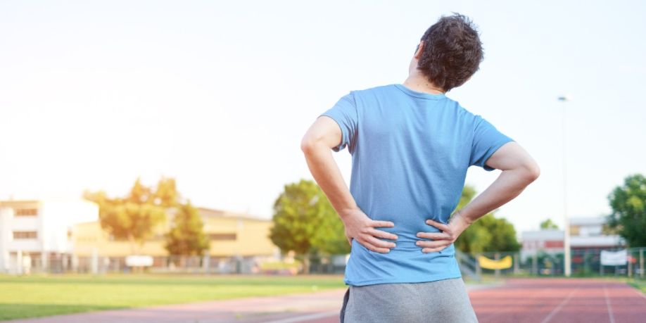 Deportista que siente dolor de espalda debido a un disco herniado