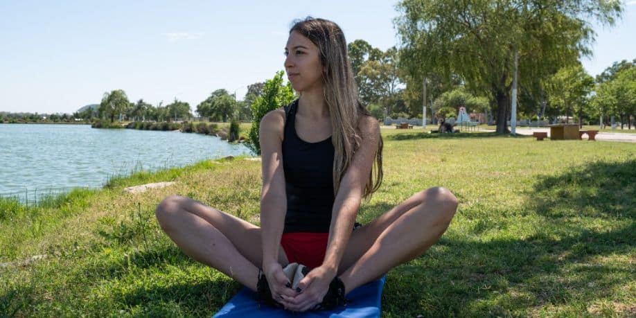 Joven deportista estira piernas y aductores en el parque