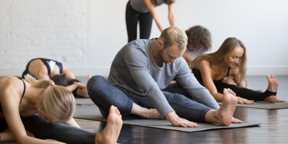 Grupo de gente deportiva joven que practica la lección de yoga con el instructor