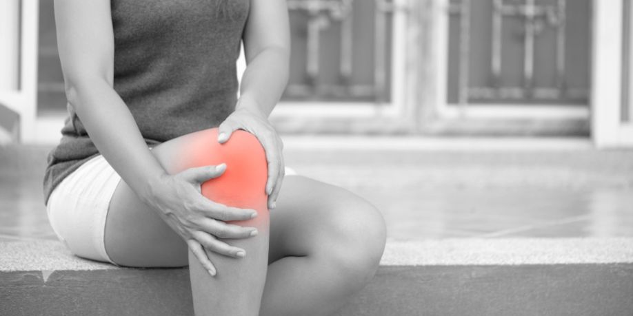 Mujer joven con dolor en la rodilla