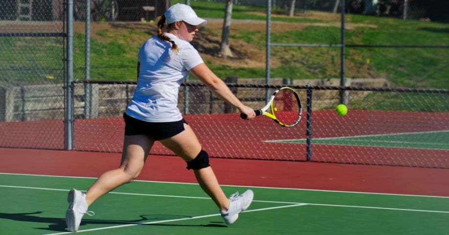 Mujer haciendo un revés a una mano en tenis